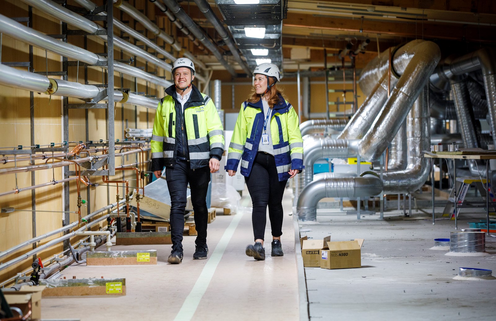 Robin Löfqvist, platschef, ByggConstruct  och Sara Tingvall, huvudprojektledare  Caverion, i fläktrummet ovanför Na­nexas lokaler