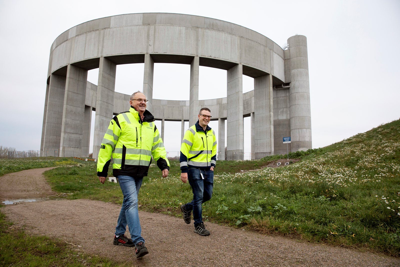 Två Caverion-medarbetare går framför det nya vattentornet i Helsingborg