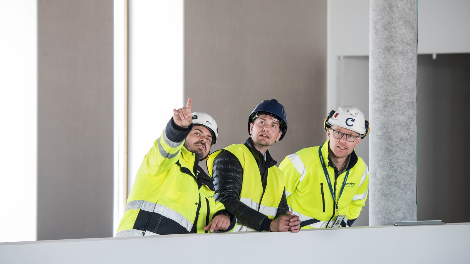 Tre Caverion-medarbetare tittar upp i taket på Skaraborgs sjukhus
